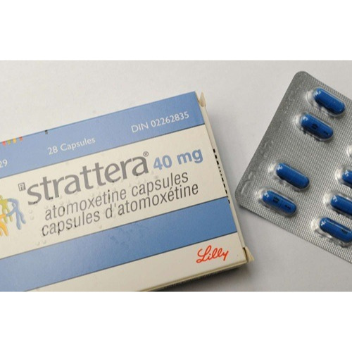 Strattera 40mg (Atomoxetine HCl) box packaging with partially visible blue capsules in blister pack
